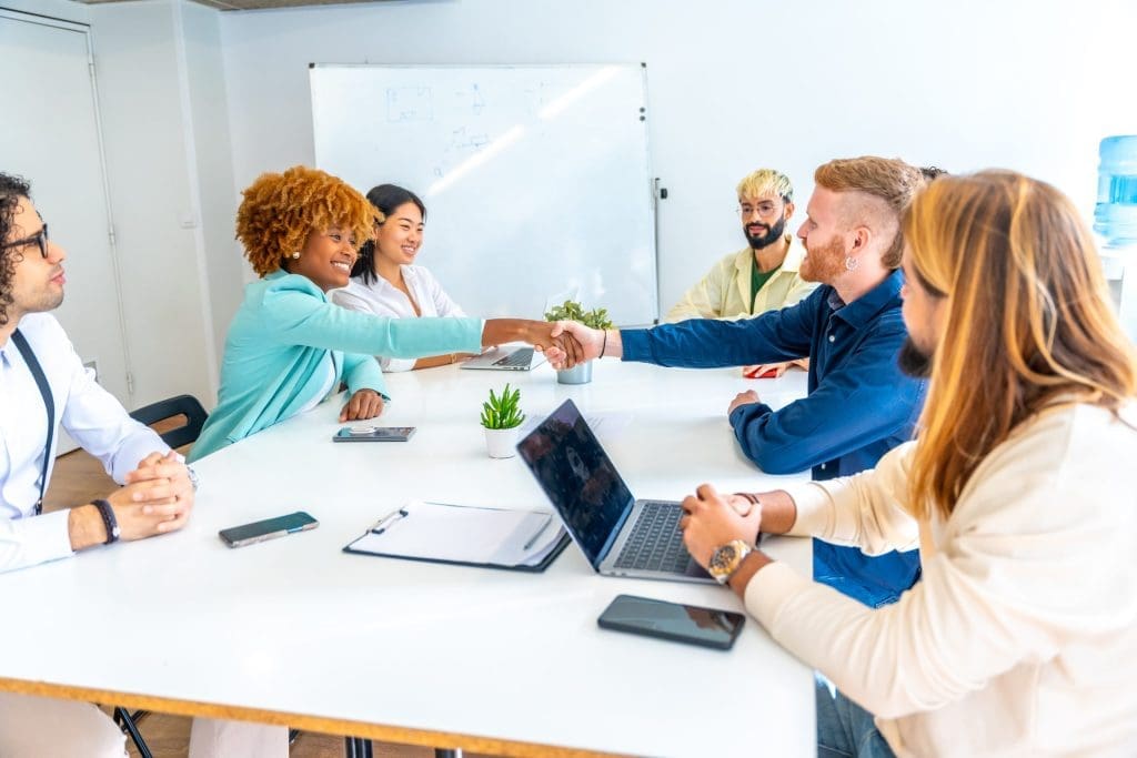 people sitting at a table and shaking hands, answering the question "what is medical billing"?