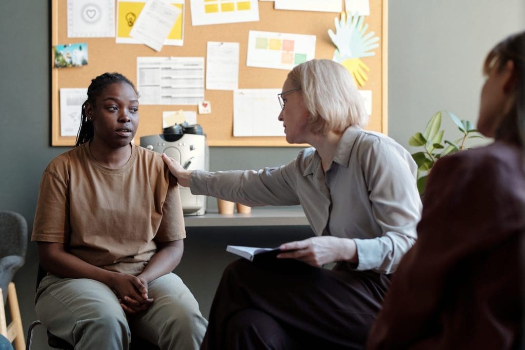 comforting a girl during a therapy session, showing the need for billing services for mental health