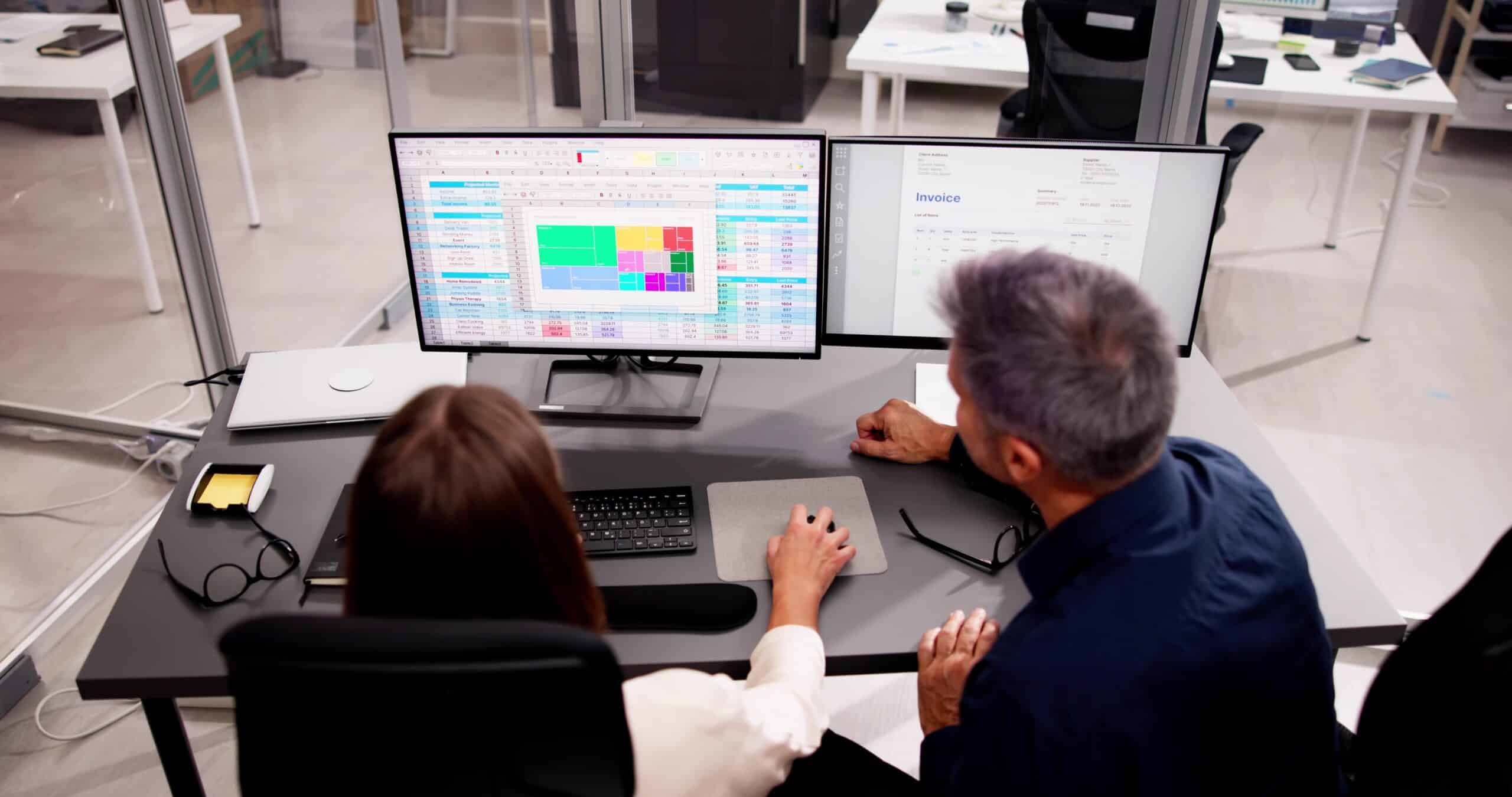 medical billing professional and medical coder working side by side at computer workstations in a healthcare office