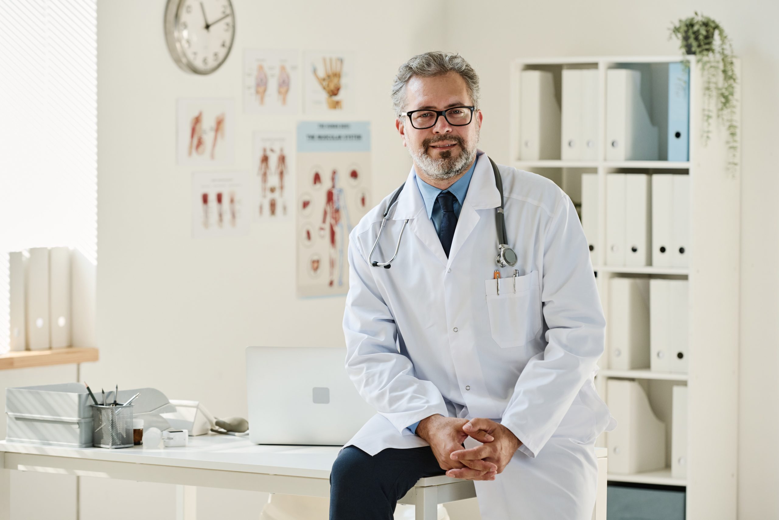 a doctor in his office looking at us representing the importance of physicians billing in his practice